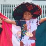 Gareth Hernández Oteo, niño tabasqueño de 11 años, posando con su medalla de oro y el uniforme de la selección mexicana tras ganar el Mundial de Muay Thai en Bangkok, Tailandia.