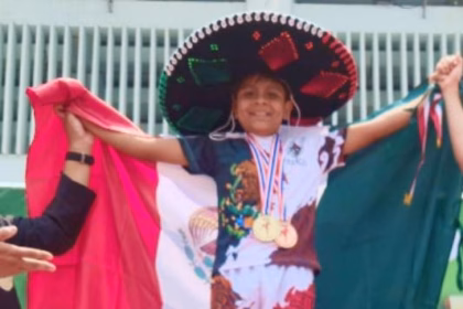 Gareth Hernández Oteo, niño tabasqueño de 11 años, posando con su medalla de oro y el uniforme de la selección mexicana tras ganar el Mundial de Muay Thai en Bangkok, Tailandia.