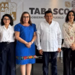 Fotografía Grupal De Seis Autoridades Del Gobierno De Tabasco Posando De Pie En Un Auditorio. En El Centro Aparece El Gobernador Javier May Rodríguez Con Guayabera Blanca, Flanqueado Por Funcionarias De Su Gabinete. Al Fondo, Una Mampara Blanca Con El Escudo De Tabasco En Dorado Y La Frase En Letras Negras: &Quot;Tabasco Gobierno Del Pueblo&Quot;, Junto A Iconografía Regional Prehispanica. La Iluminación Es Natural Y De Frente.
