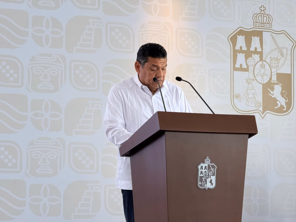 &Quot;Educación, Campo Y Tradición: Javier May Anuncia Visita De La Sep A La Chontalpa Y Entrega De Medalla Al Mérito Empresarial&Quot; 3 Retrato De Medio Cuerpo Del Gobernador Javier May Rodríguez En Un Podio De Madera Oscura Con El Escudo Oficial De Tabasco. Viste Una Guayabera Blanca Y Mantiene La Mirada Baja Hacia Sus Notas Mientras Habla Por Dos Micrófonos.