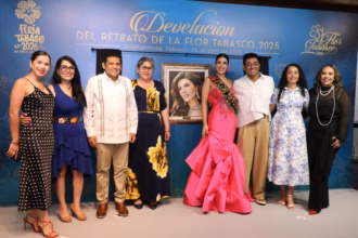 Un Grupo De Personas Está De Pie En El Escenario Frente A Un Gran Telón De Fondo Azul. El Telón De Fondo Tiene El Texto &Quot;Develación Del Retrato De La Flor Tabasco 2025&Quot; En Letras Grandes Y Doradas. En El Centro, Hay Un Retrato Enmarcado De Una Mujer Con Un Vestido Rosa Y Una Corona. Las Personas En El Escenario Están Sonriendo Y Aplaudiendo. La Mujer Del Retrato Lleva Una Banda Que Dice &Quot;Flor Tabasco 2025&Quot;.