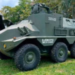 Vehículo Blindado De Seis Ruedas Del Ejército Mexicano, Modelo Vcr Tt 6X6 Con Ametralladora Montada, Exhibido Sobre Césped En El Parque Tabasco Dora María Durante La Exposición Militar 'La Gran Fuerza De México' En Villahermosa, Tabasco.