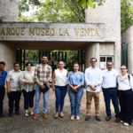 Grupo De Diez Personas, Integrado Por Funcionarios Y Personal Técnico, Posan Para Una Fotografía Oficial Frente A La Entrada Principal Del Parque Museo La Venta. El Acceso, De Estilo Rústico Y Piedra, Muestra El Nombre Del Museo En Letras Grandes De Metal.