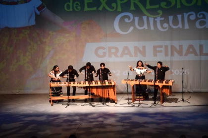 Fotografía De Un Ensamble De Marimbistas Participando En La Gran Final De Expresiones Culturales 2026 Sobre El Escenario Del Teatro Esperanza Iris. En La Imagen Se Observan Dos Marimbas De Madera; A La Izquierda, Cuatro Músicos (Tres Hombres Y Una Mujer) Ejecutan Una Pieza, Mientras Que A La Derecha, Una Pareja (Hombre Y Mujer) Toca El Segundo Instrumento.