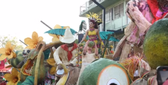 Aquí Tienes El Texto Alternativo Y La Leyenda Para La Imagen: Texto Alternativo (Alt Text): Una Toma De Ángulo Medio A Bajo Del Carro Alegórico Del Desfile &Quot;El Coprero&Quot; Del Municipio De Jalpa De Méndez, Ganador Del Primer Lugar En El Certamen De Carros Alegóricos De La Feria Tabasco. La Imagen Muestra, A La Izquierda, La Figura Del Perezoso Y Grandes Flores Tejidas