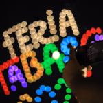 Una Persona Sostiene Un Teléfono Celular Capturando El Espectáculo De Luces En El Cielo Nocturno. Al Fondo, Drones Forman La Frase Iluminada &Quot;Feria Tabasco 2026&Quot; Con Luces Multicolores En Efecto &Quot;Bokeh&Quot;.