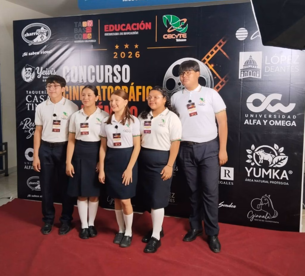 Luces, Cámara Y Reflexión: Arranca El Concurso Cinematográfico Académico Del Cecyte Tabasco 71 Fotografía Horizontal En Plano General Que Captura A Cinco Estudiantes Del Cecyte Tabasco Posando En El Vestíbulo De Un Complejo De Cinépolis. Los Jóvenes (Dos Hombres Y Tres Mujeres) Visten El Uniforme Oficial De La Institución Con Camisas Polo Blancas Y Pantalones O Faldas Oscuras, Portando Gafetes Del Evento En El Cuello.