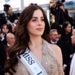 Primer Plano De Fátima Bosch, Miss Universe 2025, En La Alfombra Roja De Cannes. Luce Un &Quot;Jewel Dress&Quot; En Tono Nude Con Pedrería Floral Y Lleva La Banda Oficial De Miss Universe Cruzada Sobre El Hombro. De Fondo Se Ven Fotógrafos De Prensa.