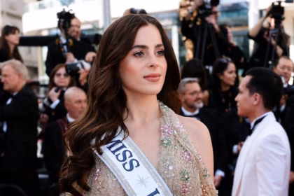 Primer Plano De Fátima Bosch, Miss Universe 2025, En La Alfombra Roja De Cannes. Luce Un &Quot;Jewel Dress&Quot; En Tono Nude Con Pedrería Floral Y Lleva La Banda Oficial De Miss Universe Cruzada Sobre El Hombro. De Fondo Se Ven Fotógrafos De Prensa.