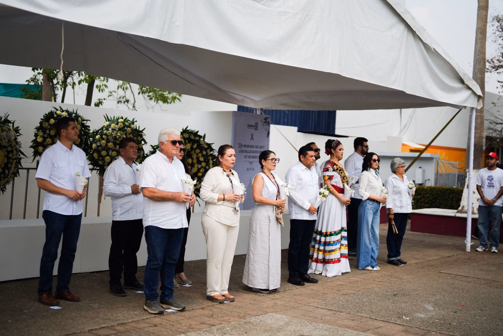 Fotografía De Una Guardia De Honor Encabezada Por El Gobernador Javier May Rodríguez Y Funcionarios Estatales Bajo Una Lona Blanca. El Mandatario, Vestido Con Una Guayabera Blanca, Se Encuentra En El Centro De Una Fila De Hombres Y Mujeres Que Visten Mayoritariamente De Blanco O Colores Claros En Señal De Luto