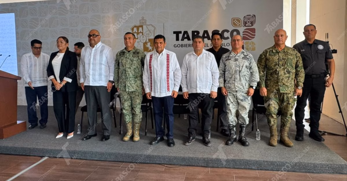 Gira De Obras, Blindaje Por El Mundial 2026 Y Visita Presidencial: Javier May Encabeza Balance Integral De Seguridad Y Desarrollo En Tabasco 2 Otografía De Prensa En Plano Entero Y Ángulo Frontal Que Muestra A Diez Funcionarios Públicos Alineados De Pie Sobre Un Presídium Durante Una Conferencia De Prensa Del Gobierno De Tabasco. Al Centro Destaca El Gobernador Javier May Rodríguez Vistiendo Una Guayabera Blanca Con Bordados Verticales Rojos Y Pantalón Oscuro.