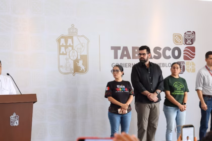 El Gobernador Javier May Rodríguez En El Podio Durante Una Conferencia De Prensa, Acompañado Por Miembros De Su Gabinete Y Equipo De Trabajo, Quienes Permanecen De Pie A Su Lado Frente A Un Muro Con El Logotipo Oficial Del Gobierno De Tabasco.