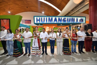 Una Fotografía Horizontal De Plano Medio Largo Captura El Corte De Listón Inaugural Del Pabellón De Huimanguillo En La Nave &Quot;Macuilis&Quot; De La Feria Tabasco 2026. Al Centro De La Imagen, El Gobernador Javier May Rodríguez, Vestido Con Guayabera Blanca Y Pantalón Oscuro, Sostiene La Cinta Junto A La Alcaldesa Mari Luz Velázquez.