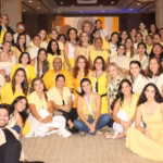 Una Fotografía Grupal A Color Captura A Un Numeroso Grupo De Emprendedores Y Organizadores De Merkadito Bazar Dentro De Un Salón Del Hotel Hyatt Regency Villahermosa. La Mayoría De Las Personas, Principalmente Mujeres, Visten Prendas En Tonos Amarillos Y Blancos, Creando Una Imagen Vibrante Y Uniforme. El Grupo Posa Sonriente Frente A La Cámara En El Marco De La 10ª Edición Del Evento; Algunos Están Sentados En El Suelo Al Frente, Mientras Otros Permanecen De Pie En Varios Niveles Hacia Atrás.