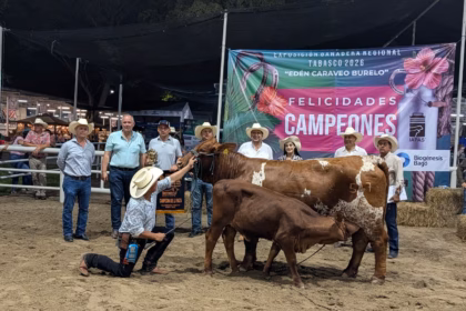 Fotografía Panorámica En Exteriores De La Premiación De La Exposición Ganadera Regional Tabasco 2026 En El Marco De La Feria Tabasco. Un Nutrido Grupo De Productores, Ganaderos Con Sombreros Vaqueros Y Autoridades Posan Sonrientes Frente A Dos Lonas Publicitarias.