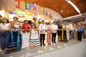 Fotografía De Una Ceremonia De Corte De Listón Frente A La Entrada Del Pabellón De Jalpa De Méndez. En El Centro, El Gobernador Javier May Rodríguez Sostiene Las Tijeras Junto A Aurora Raleigh De La Cruz (Blusa Rosa Floral) Y La Flor Tabasco 2026, María José Hernández Vera, En Traje Regional Blanco. A La Izquierda Destacan La Embajadora De Jonuta Con Su Banda Oficial Y Autoridades Municipales Con Chalecos Rojos Y Blancos.