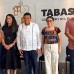 Foto De Prensa De Plano Entero Que Muestra A Cinco Funcionarios Públicos De Tabasco Posando De Pie, Alineados Horizontalmente En Un Estrado Durante Una Conferencia Oficial.