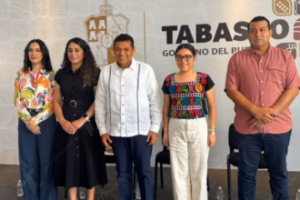 Foto De Prensa De Plano Entero Que Muestra A Cinco Funcionarios Públicos De Tabasco Posando De Pie, Alineados Horizontalmente En Un Estrado Durante Una Conferencia Oficial.