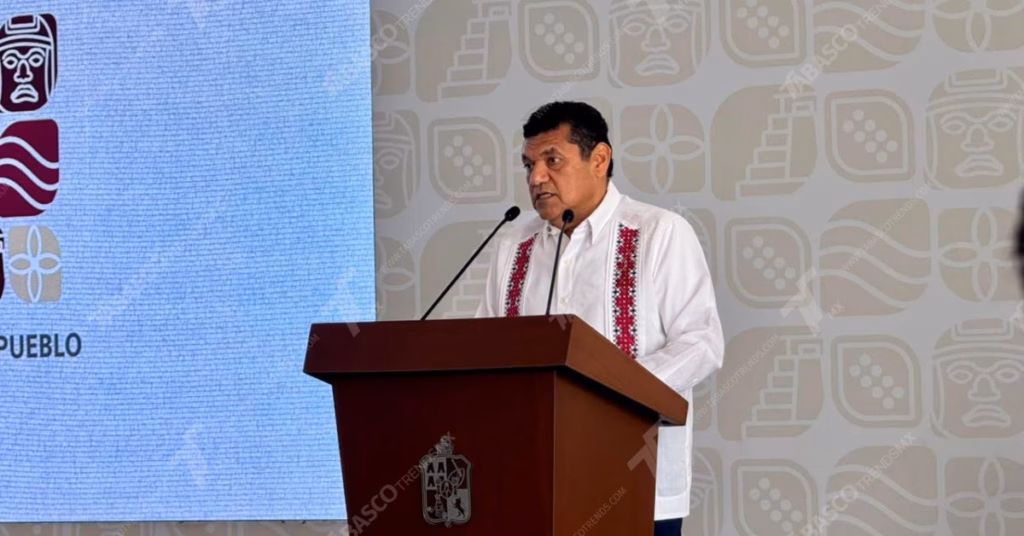 Gira De Obras, Blindaje Por El Mundial 2026 Y Visita Presidencial: Javier May Encabeza Balance Integral De Seguridad Y Desarrollo En Tabasco 3 Gobernador De Tabasco, Javier May Rodríguez, Hablando Desde Un Podio De Madera Oscura Con El Escudo Heráldico Del Estado Al Frente.