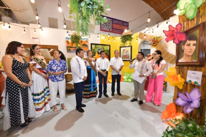 El Gobernador Javier May Rodríguez Junto A La Presidenta Honoraria Del Dif Tabasco, Aurora Raleigh De La Cruz, Y La Flor De Oro, María José Hernández Vera, Recorren El Stand De Emiliano Zapata En La Feria Tabasco 2026. En El Interior Del Espacio, Decorado Con Cuadros Artísticos, Plantas Colgantes Y Una Serie De Luces Cálidas, Un Expositor Explica Los Detalles De La Muestra Cultural A Las Autoridades Y A La Embajadora Del Municipio, Mariú Mendoza Cabrera. A La Derecha Destaca Un Retrato Enmarcado Sobre Una Estructura De Bambú Adornada Con Flores Multicolores De Gran Tamaño.