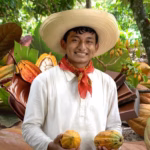 Primer Plano De Granos De Cacao Secos Y Fermentados Con Su Característico Color Marrón Rojizo, Amontonados De Forma Natural. Sobre La Imagen, Destaca El Logotipo Oficial Del Impi (Instituto Mexicano De La Propiedad Industrial) Y Un Sello Dorado Que Dice &Quot;Indicación Geográfica Protegida&Quot;.