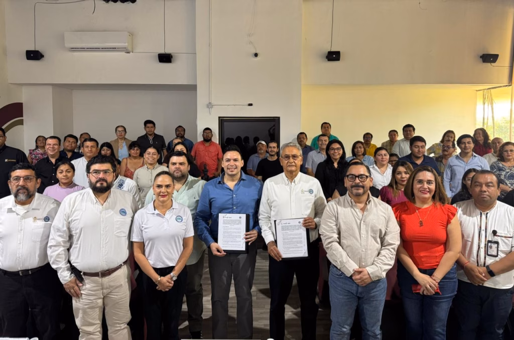 Uttab Consolida Su Liderazgo En El Marco De Su 30 Aniversario: Firma Convenio Estratégico Con La Secretaría De Turismo Y Desarrollo Económico 71 Fotografía Grupal En El Interior De Un Auditorio Universitario Con Plano Abierto Y Perspectiva Frontal. En La Primera Fila, Un Presídium Integrado Por Directivos De La Uttab Y Representantes Del Gobierno De Tabasco, Entre Ellos Juan Basilio Taracena Con Camisa Azul, Posan Sonrientes Sosteniendo Las Carpetas Oficiales Del Convenio Institucional Firmado. Detrás De Ellos, Decenas De Docentes, Administrativos Y Personal Universitario Se Distribuyen En Las Gradas Del Recinto, Conformando Una Gran Audiencia Que Acompaña El Acto Protocolario. El Espacio Cuenta Con Iluminación Clara Y Un Aire Acondicionado Visible En La Parte Superior Izquierda De La Pared.
