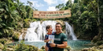Un Padre Sonriente Abraza A Su Pequeño Hijo, Quien Sostiene Un Dibujo De &Quot;¡Feliz Día Papá!&Quot;, Frente A Las Imponentes Cascadas De Agua Blanca En Teapa, Tabasco, Rodeados De Una Exuberante Selva Verde Y Un Río De Aguas Cristalinas Bajo Una Gran Pancarta Festiva.