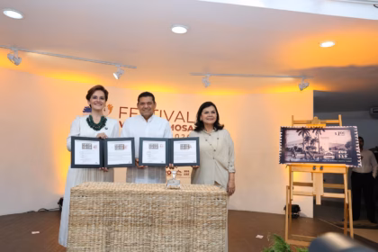El Gobernador Javier May Rodríguez, La Directora General De Sepomex Victoria Abreu González Y La Alcaldesa Yolanda Osuna Huerta Sostienen Las Carpetas Protocolarias Del Timbre Postal Conmemorativo En El Escenario Del Festival Villahermosa 2026, Junto A Un Caballete De Madera Que Exhibe La Réplica A Gran Escala De La Estampilla De Correos De México.