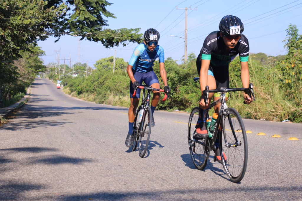 Día Mundial De La  Y Las Mejores Rutas Para Pedalear En Tabasco, Dos Ciclistas De Ruta Avanzan A Gran Velocidad En Sus Bicicletas De Carreras Sobre Una Carretera De Asfalto En Un Día Soleado.