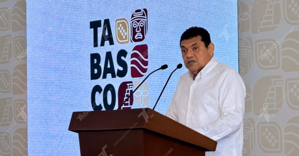 Mañanera De Javier May: Presentan Festival Ceiba, Educación Superior Y Saneamiento Ganadero 71 Primer Plano De Javier May Rodríguez, Gobernador De Tabasco, De Pie Y Hablando En Un Podio De Madera Durante Una Conferencia De Prensa. Viste Una Guayabera Blanca Formal Y Está Posicionado Frente A Una Gran Pantalla Led De Fondo.