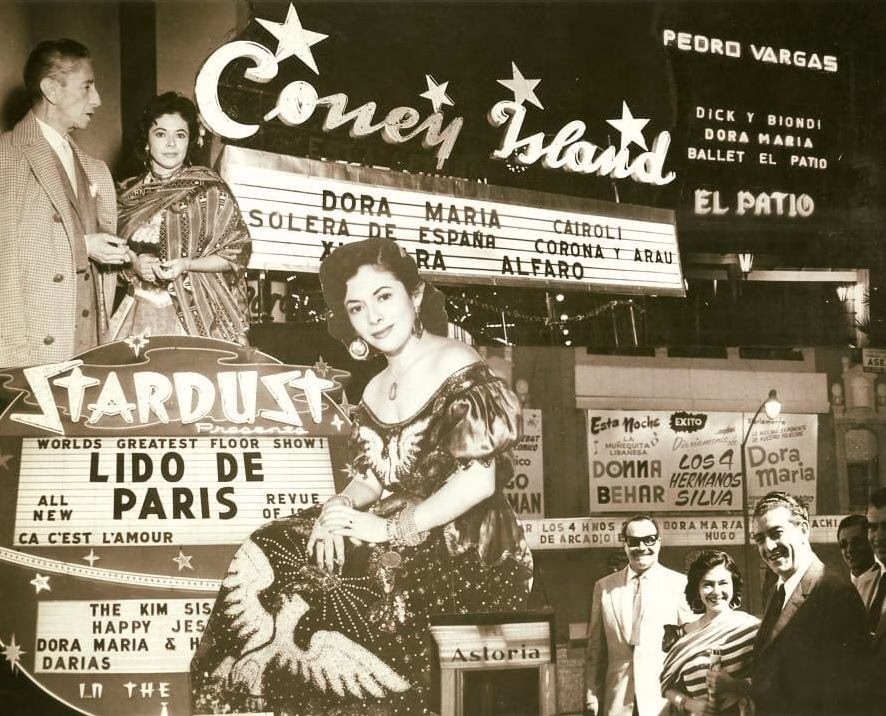 Se Presenta Un Collage De Fotografías Históricas Y Marquesinas Publicitarias Que Celebran La Carrera Internacional De La Cantante Dora María. En La Parte Superior, Bajo Un Gran Letrero Luminoso De &Quot;Coney Island&Quot;, Se Observa Una Marquesina De Espectáculos Donde Destaca El Nombre De &Quot;Dora Maria&Quot;, Junto A Figuras Como Pedro Vargas Y El Ballet El Patio.