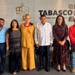 Fotografía Oficial De Un Grupo De Ocho Funcionarios Públicos De Pie Y Alineados, Posando Sonrientes Ante La Cámara. Al Centro Se Encuentra El Gobernador De Tabasco, Javier May Rodríguez, Vistiendo Una Guayabera Blanca Con Bordados Tradicionales. A Su Lado Izquierdo Destaca Mónica Fernández Balboa Con Un Conjunto Color Ocre.