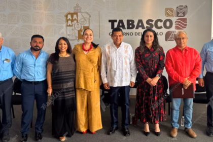 Fotografía Oficial De Un Grupo De Ocho Funcionarios Públicos De Pie Y Alineados, Posando Sonrientes Ante La Cámara. Al Centro Se Encuentra El Gobernador De Tabasco, Javier May Rodríguez, Vistiendo Una Guayabera Blanca Con Bordados Tradicionales. A Su Lado Izquierdo Destaca Mónica Fernández Balboa Con Un Conjunto Color Ocre.