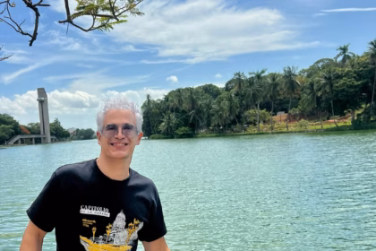Io Camejo, Sonriente Y Con Gafas De Sol, Sentado Sobre Un Muro De Piedra A Orillas De La Laguna De Las Ilusiones En Villahermosa, Vistiendo La Misma Playera Negra De La Habana.