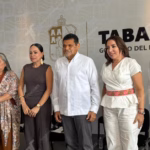 Una Toma De Ángulo Medio En Primer Plano Muestra A Seis Funcionarios Gubernamentales De Pie, Sonriendo Y Mirando Hacia La Cámara, Posando Juntos En La Conferencia De Prensa &Quot;Mañanera De Javier May&Quot; Para Presentar Iniciativas Como El Festival Ceiba, Educación Superior En Jonuta, Y Saneamiento Ganadero. Un Cartel De Fondo En La Pared Gris Pálido Detrás De Ellos Presenta El Escudo De Armas Nacional De México Y, A La Derecha, El Texto Grande, En Español, &Quot;Tabasco Gobierno Del Pueblo&Quot;.