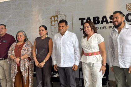 Una Toma De Ángulo Medio En Primer Plano Muestra A Seis Funcionarios Gubernamentales De Pie, Sonriendo Y Mirando Hacia La Cámara, Posando Juntos En La Conferencia De Prensa &Quot;Mañanera De Javier May&Quot; Para Presentar Iniciativas Como El Festival Ceiba, Educación Superior En Jonuta, Y Saneamiento Ganadero. Un Cartel De Fondo En La Pared Gris Pálido Detrás De Ellos Presenta El Escudo De Armas Nacional De México Y, A La Derecha, El Texto Grande, En Español, &Quot;Tabasco Gobierno Del Pueblo&Quot;.