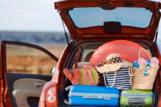Antes De Viajar: El Checklist Que Todo Tabasqueño Debe Seguir Para Unas Vacaciones Sin Riesgos — Fotografía De La Cajuela Abierta De Un Automóvil Cargada Con Maletas De Colores, Sombreros De Playa E Inflables, Ilustrando La Preparación Para Salir A Carretera.