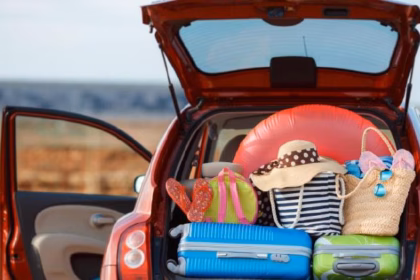 Antes De Viajar: El Checklist Que Todo Tabasqueño Debe Seguir Para Unas Vacaciones Sin Riesgos — Fotografía De La Cajuela Abierta De Un Automóvil Cargada Con Maletas De Colores, Sombreros De Playa E Inflables, Ilustrando La Preparación Para Salir A Carretera.