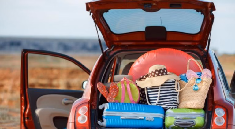 Antes De Viajar: El Checklist Que Todo Tabasqueño Debe Seguir Para Unas Vacaciones Sin Riesgos — Fotografía De La Cajuela Abierta De Un Automóvil Cargada Con Maletas De Colores, Sombreros De Playa E Inflables, Ilustrando La Preparación Para Salir A Carretera.