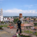 Montaje Fotográfico Del Futbolista Jesús Gallardo Con La Camiseta De La Selección Mexicana, Posando Sobre Un Balón Frente A La Plaza Principal Y El Templo De San Antonio De Padua En Cárdenas, Tabasco.