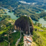 Vista Aérea De La Piedra Del Peñol En Guatapé, Colombia, Un Enorme Monolito Rocoso Rodeado Por Un Vasto Embalse De Aguas Verdes, Colinas Frondosas Y Vegetación Tropical.
