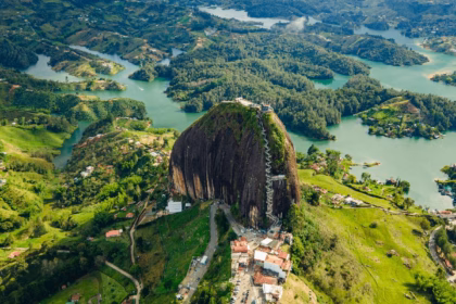Vista Aérea De La Piedra Del Peñol En Guatapé, Colombia, Un Enorme Monolito Rocoso Rodeado Por Un Vasto Embalse De Aguas Verdes, Colinas Frondosas Y Vegetación Tropical.