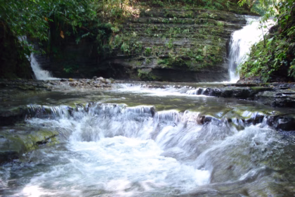 Una Cascada De Agua Cristalina Fluye Entre Rocas Escalonadas Formando Pequeñas Pozas Naturales En Medio De La Densa Selva De Huimanguillo. Al Fondo Se Aprecian Caídas De Agua Adicionales Y Paredes Rocosas Rodeadas De Vegetación Verde Y Húmeda.