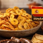 Primer Plano De Una Mesa De Madera Rústica Con Un Gran Tazón Central De Frituras Mixtas De Plátano (Chips Y Tiras). A La Izquierda Hay Un Tazón De Jalapeños En Vinagre Y A La Derecha Un Tazón De Cebolla Morada Picada. En Primer Plano, Sobre Una Hoja De Plátano, Hay Varias Salchichas A La Parrilla Y Una Pila De Tortillas De Maíz. Flotando En La Esquina Superior Derecha, Un Panel Dorado Muestra Las Banderas De España (Izquierda) Y Argentina (Derecha) Separadas Por Un &Quot;Vs&Quot; Dorado, Con Los Nombres De Los Países Debajo. Todo El Montaje Sugiere Una Reunión Para Ver Un Partido De Fútbol.