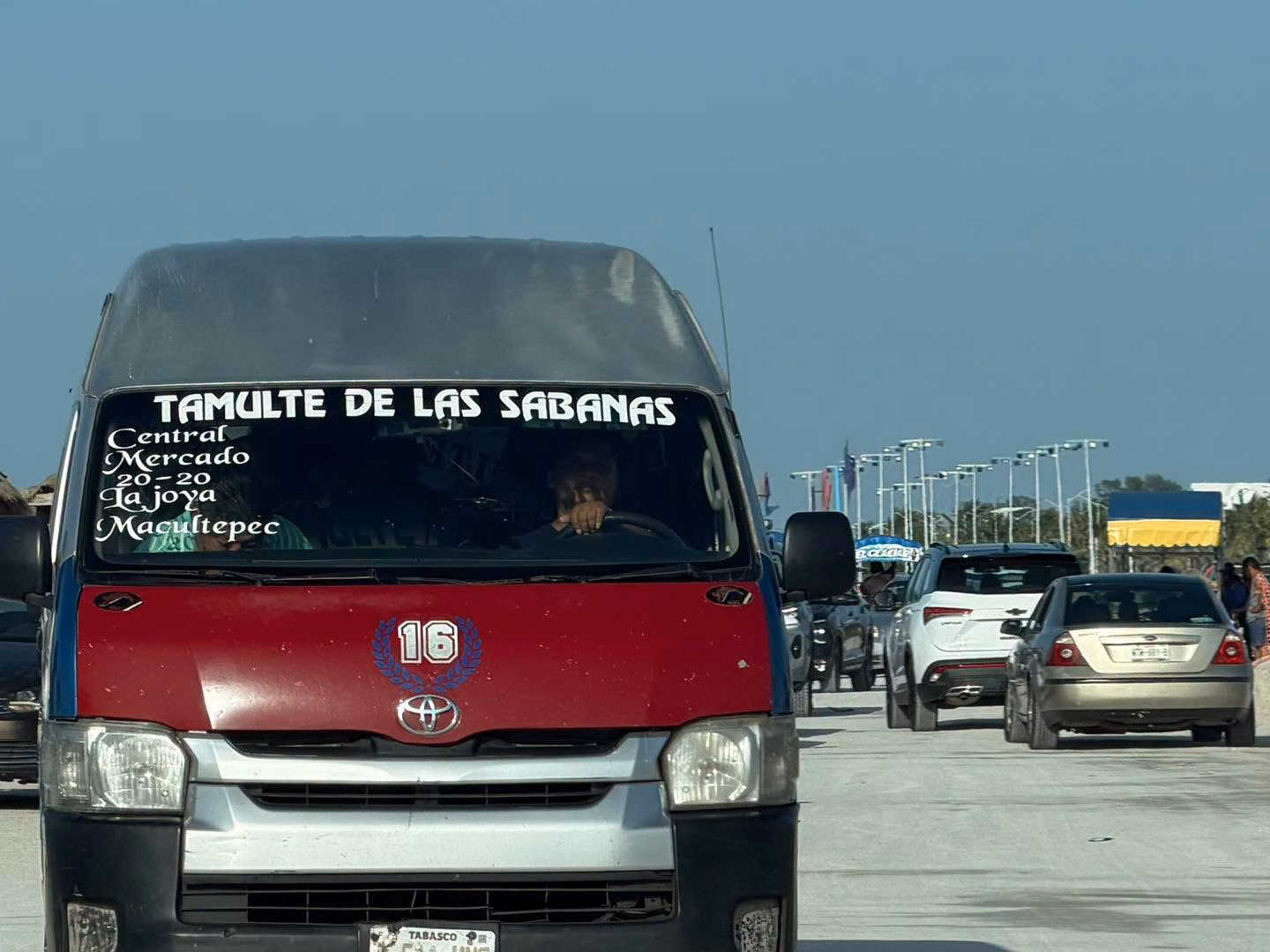 Una Combi De Transporte Público De Color Rojo Y Negro Con La Ruta Tamulté De Las Sabanas Circulando Por Una Carretera, Evidenciando La Llegada De Visitantes Tabasqueños Durante La Feria Carmen 2026.