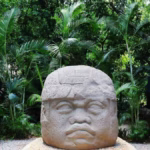 Cabeza Colosal Olmeca Expuesta Entre Vegetación Tropical En El Parque Museo La Venta En Villahermosa, Tabasco.