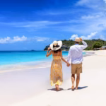 Una Pareja Caminando De La Mano Por La Orilla De Una Playa Paradisíaca De Arena Blanca Y Mar Turquesa, Representando Las 3 Playas Cerca De Tabasco Que Te Sorprenderán Este Verano.