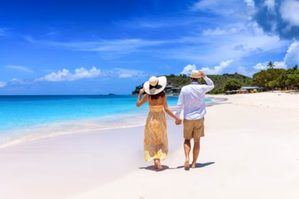 Una Pareja Caminando De La Mano Por La Orilla De Una Playa Paradisíaca De Arena Blanca Y Mar Turquesa, Representando Las 3 Playas Cerca De Tabasco Que Te Sorprenderán Este Verano.
