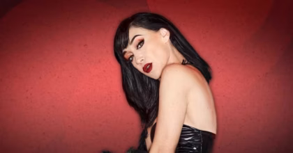Retrato Promocional De La Cantante Y Actriz Mexicana Susana Zabaleta Gratis En Villahermosa, Luciendo Cabello Negro Corto, Labial Rojo Y Vestuario Glamuroso Sobre Un Fondo Rojo.
