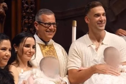 Martha Higareda Y Lewis Howes Durante La Ceremonia Religiosa Del Bautizo De Sus Hijas Mellizas En Compañía De Un Sacerdote.